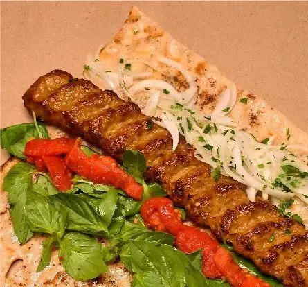 کباب ممتاز دوزلی شعبه صادقیه با ظاهری وسوسه‌انگیز، شامل کباب گوشت گریل شده، نان داغ، پیاز، ریحان و فلفل کبابی.