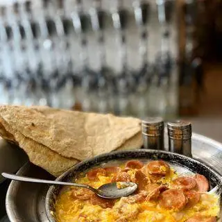 صبحانه عربی: املت تخم مرغ و سوسیس گرم با نان تازه و ادویه‌جات در کافه عربی میر مهنا، لذت طعم اصیل در فضایی دلنشین.