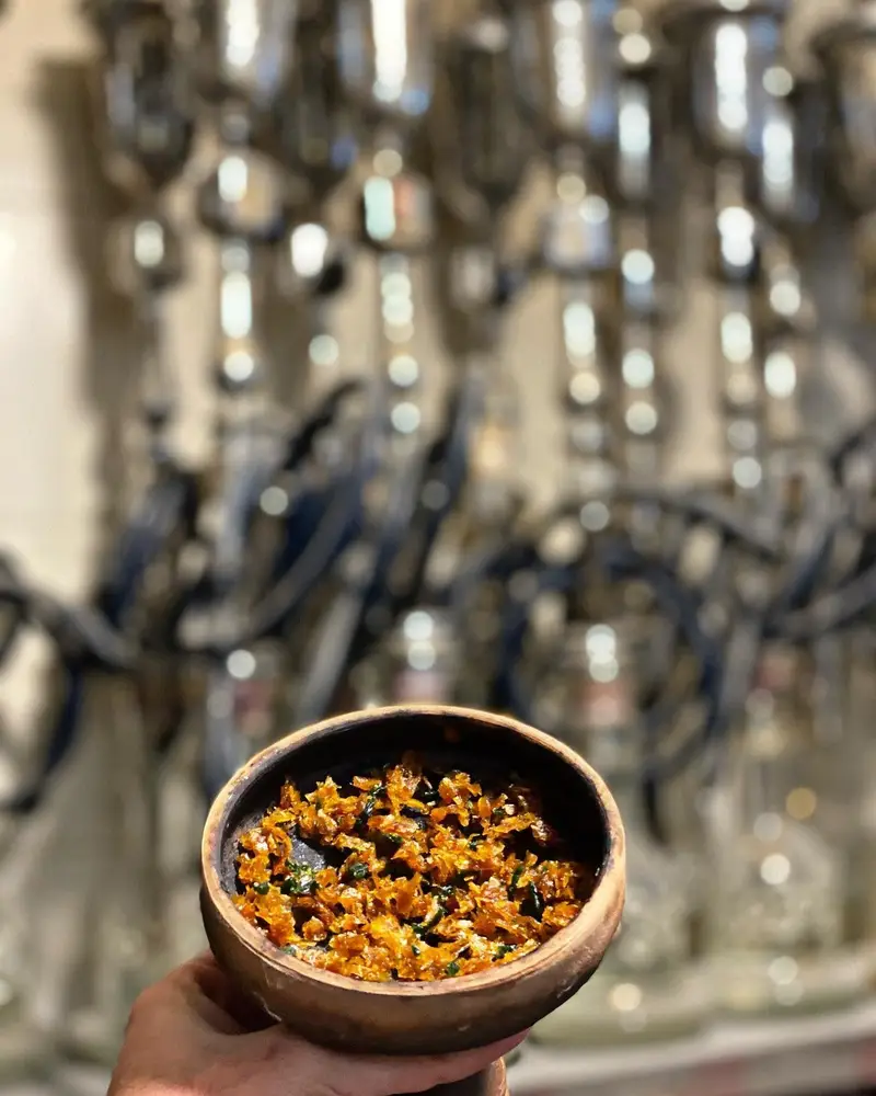 آماده سازی قلیان در کافه عربی میر مهنا: کاسه پر از تنباکوی تازه و معطر، نشان‌دهنده فضای دلنشین و متنوع ما.