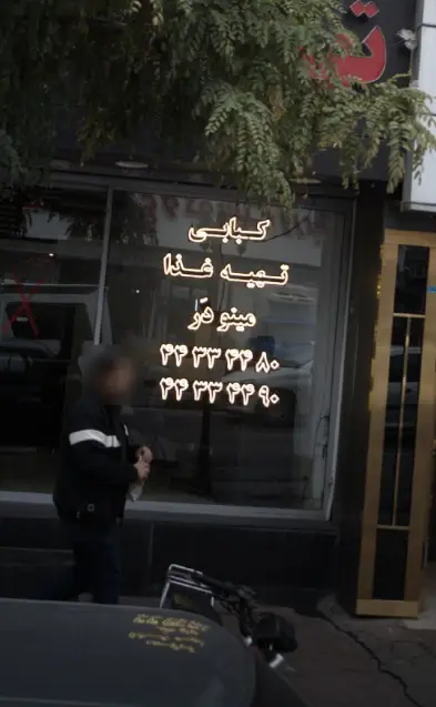 نمای بیرونی کبابی و تهیه غذای مینودر با تابلو نئون و شماره تماس ۳۳۳۳۳۳۸۰ و ۳۳۳۳۳۳۹۰، آماده ارائه انواع غذاهای خانگی و کبابی