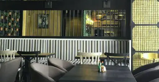 دکوراسیون داخلی مدرن و شیک رستوران ایتالیایی ای تی اف، با میز و صندلی‌های راحت، دیوارهای راه‌راه و محیطی دلنشین برای مشتریان.