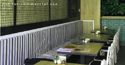 فضای داخلی دلپذیر رستوران ایتالیایی ای تی اف با نیمکت‌های راه‌راه خاکستری و سفید، میزهای چوبی و صندلی‌های شیک برای مشتریان.