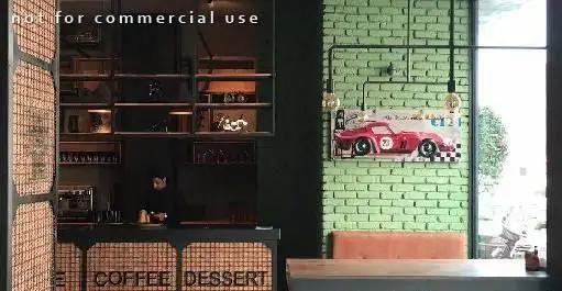 فضای داخلی مدرن و دکوراسیون صنعتی رستوران ایتالیایی ای تی اف با کانتر کافی و دسر، دیوار آجری سبز و تابلو ماشین کلاسیک.