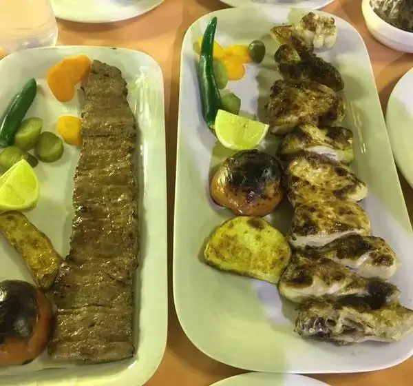 نمایی دلپذیر از کباب کوبیده و جوجه کباب لذیذ در رستوران باغ بهشت. غذاهای سنتی ایرانی با دورچین تازه و جذاب برای مشتریان.