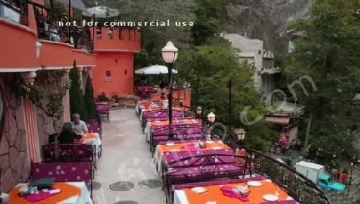 رستوران باغ بهشت، فضایی رویایی و سرسبز با چیدمان زیبای میز و صندلی‌ها در فضای باز با چشم‌انداز کوهستانی بی‌نظیر برای مشتریان.