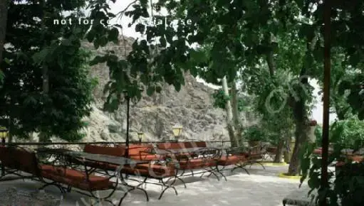 فضای باز و دلنشین رستوران باغ بهشت با میز و نیمکت‌های راحت در طبیعتی سرسبز و کوهستانی، مکانی عالی برای صرف غذا و آرامش