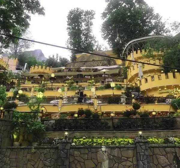 رستوران باغ بهشت، مکانی بی‌نظیر با طراحی پله‌ای و بالکن‌های زیبا، محیطی سرسبز و روشن برای تجربه‌ای دلپذیر از صرف غذا در فضای باز.