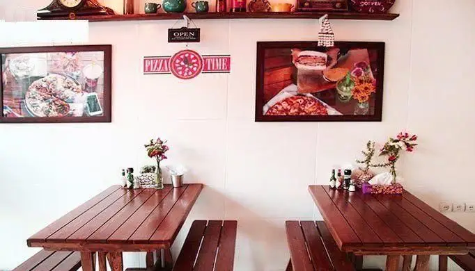 فضای داخلی دلنشین و مدرن فست فود آوان، با میز و نیمکت‌های چوبی راحت، دکوراسیون جذاب و تصاویر متنوع پیتزا و فست فودهای لذیذ.