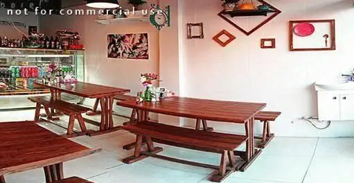 فضای داخلی دنج و مدرن فست فود آوان با میز و نیمکت‌های چوبی، ویترین نوشیدنی‌ها و دکوراسیون ساده و دلنشین مناسب برای صرف غذا.