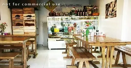 نمای داخلی گرم و صمیمی فست فود آوان با دکوراسیون چوبی، میز و نیمکت‌های بلند روستیک، محیطی ایده‌آل برای لذت بردن از انواع فست فودها.