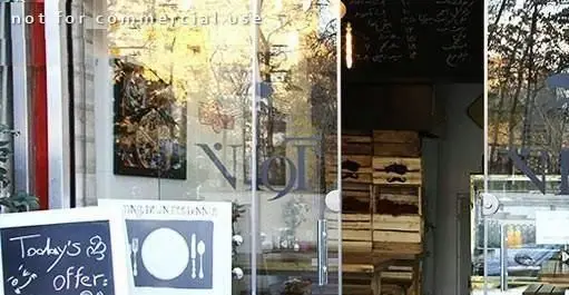 نمای بیرونی جذاب فست فود آوان با شیشه های رفلکتیو، شامل تابلو ویژه "پیشنهاد امروز" و نمادهای غذا و منوی داخلی.