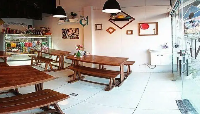 فضای داخلی فست فود آوان با میز و نیمکت‌های چوبی، ویترین نوشیدنی و محیطی تمیز و دلباز مناسب خانواده و دوستان.