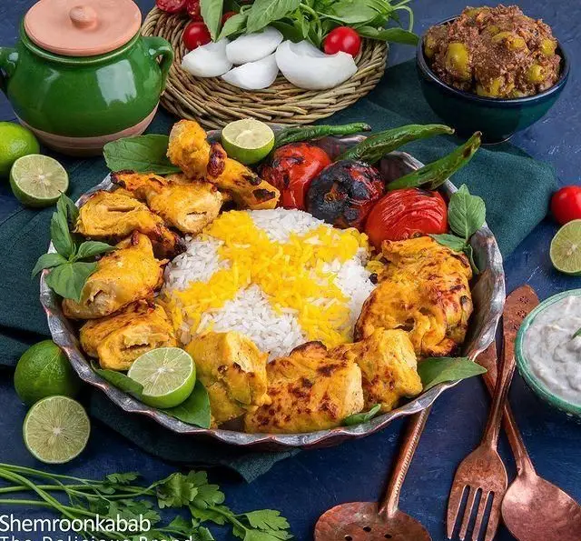 چلو جوجه کباب شمرون کباب با برنج زعفرانی، گوجه و فلفل کبابی، لیمو ترش تازه و مخلفات. طعم لذیذ غذای ایرانی اصیل.