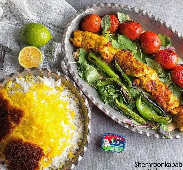 چلو جوجه کباب شمرون کباب، غذای محبوب و سنتی ایرانی با برنج زعفرانی، ته دیگ طلایی، گوجه و فلفل کبابی تازه.