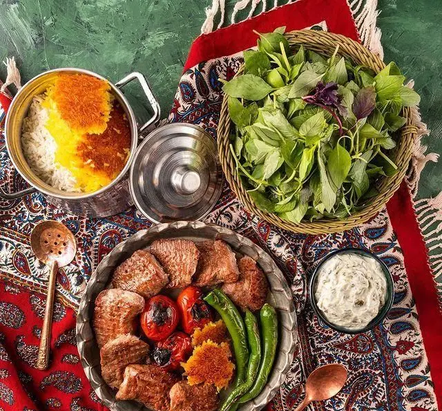 سفره سنتی شمیرون کباب شامل کباب گوشت، گوجه و فلفل کبابی، پلو زعفرانی با ته دیگ، سبزی تازه و ماست محلی.