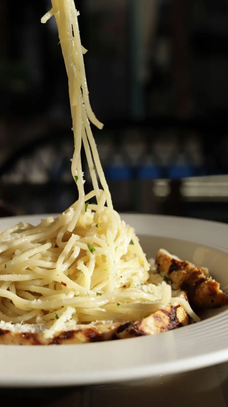 پاستا اسپاگتی با سس خامه‌ای و مرغ گریل شده تازه در کافه‌حیات هزار افسانْ. غذای ایتالیایی لذیذ و باکیفیت برای تجربه‌ای دلپذیر.