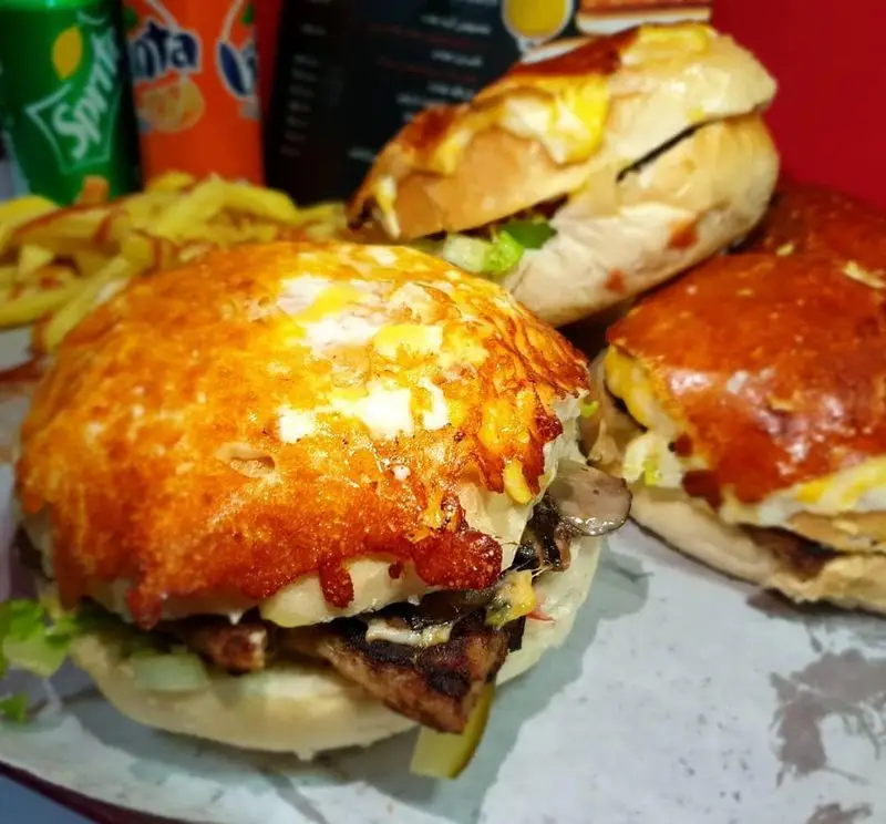 سفارش فست فود پاندا: سه برگر/ساندویچ خوشمزه با پنیر برشته، گوشت گریل شده، قارچ و کاهو، همراه با سیب‌زمینی و نوشابه.