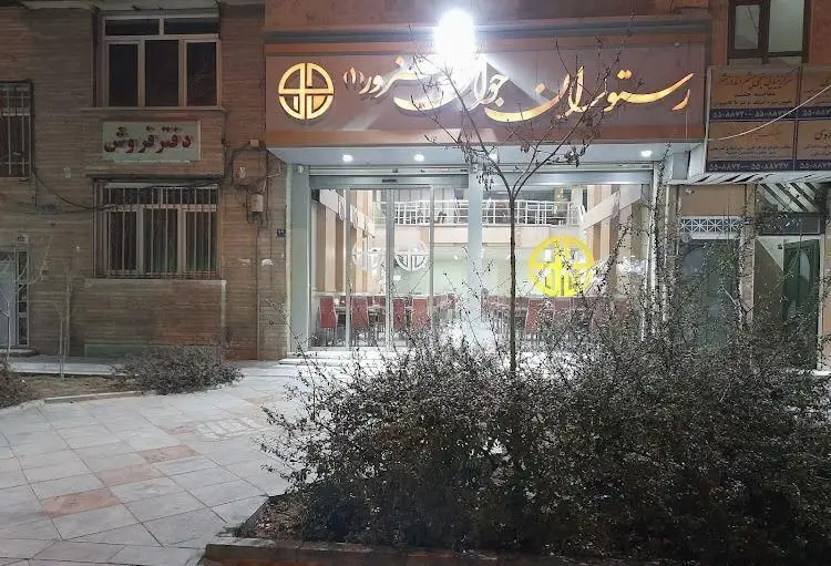 تصویری جذاب از نمای بیرونی رستوران جوان هنرور۱ در شب، با تابلوی روشن و ورودی دلنشین که محیطی عالی برای تجربه غذای لذیذ را نوید می‌دهد.