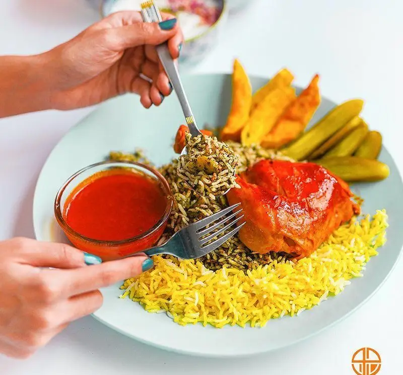 وعده غذایی لذیذ در رستوران جوان هنرور۱: چلو مرغ زعفرانی و سبزی پلو با دورچین کامل سیب‌زمینی و ترشی. تجربه‌ای اصیل از غذای ایرانی.