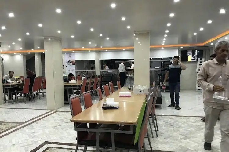 فضای داخلی رستوران جوان هنرور۱ با نورپردازی روشن، میز و صندلی‌های مرتب و حضور مشتریان و پرسنل فعال، محیطی دلنشین برای صرف غذا.