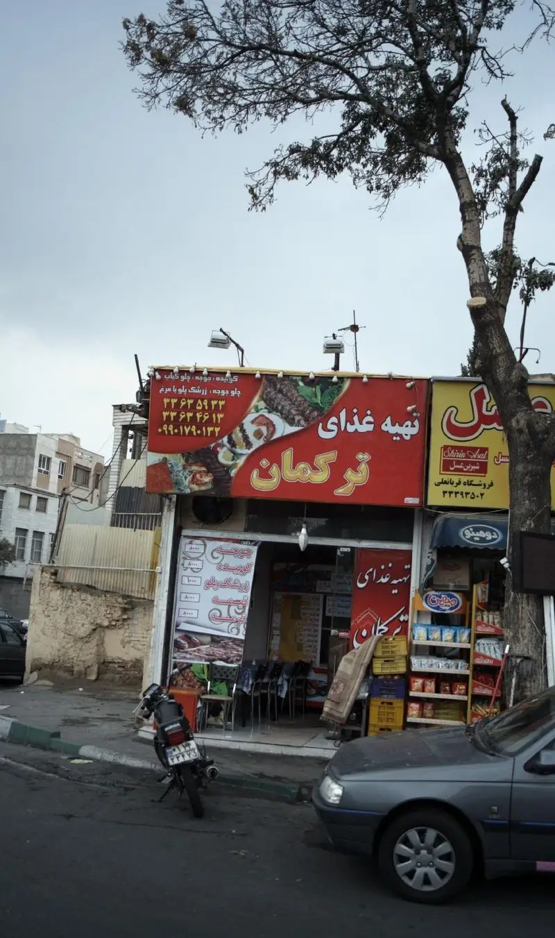 تهیه غذای ترکمان: رستورانی با انواع کباب و غذای ایرانی، آماده سازی غذای بیرون بر با کیفیت عالی، اطلاعات تماس روی تابلو.