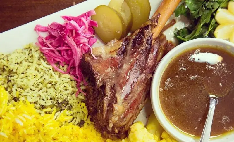 ماهیچه گوسفندی لذیذ با چلو زعفرانی و سبزی پلو در باغچه رستوران سنتی صحرا. تجربه طعم اصیل غذای ایرانی و سنتی.