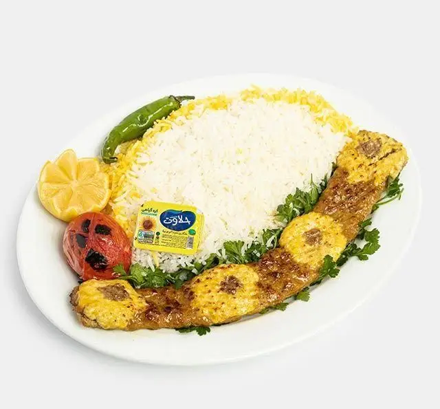 چلو جوجه کباب سنتی رستوران آفاق با برنج زعفرانی، گوجه کبابی، فلفل سبز، لیمو و کره جلاوت. یک غذای اصیل ایرانی.