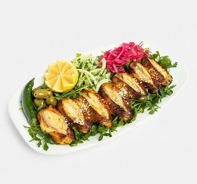 بال و کتف کبابی خوشمزه رستوران سنتی آفاق با تزئین لیمو، زیتون، فلفل سبز و سبزیجات تازه؛ غذای ایرانی لذیذ.