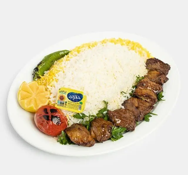 چلوکباب اصیل ایرانی شامل کباب گوشت، برنج زعفرانی، گوجه و فلفل کبابی، لیمو و کره در رستوران سنتی آفاق