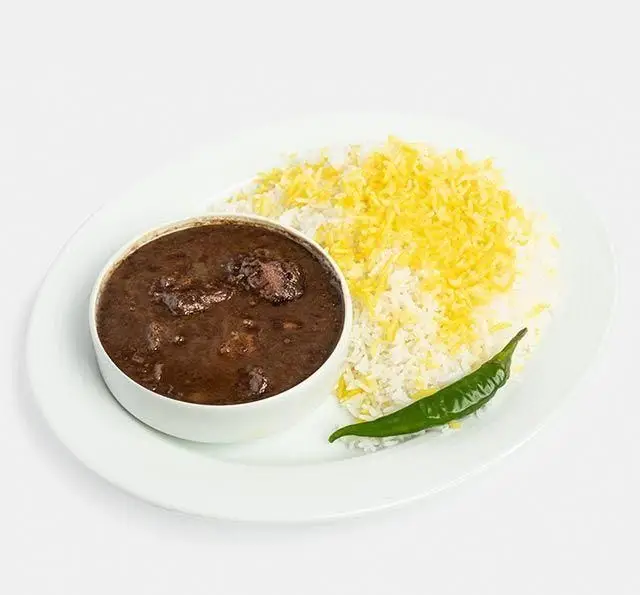 خورش فسنجان اصیل ایرانی با تکه‌های گوشت، برنج زعفرانی و فلفل سبز، آماده سرو در رستوران سنتی آفاق.