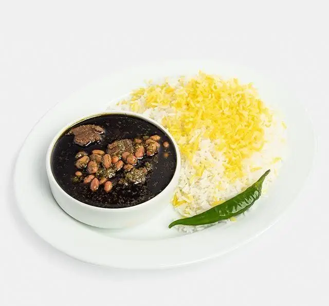 خورشت قرمه سبزی لذیذ با برنج ایرانی زعفرانی و کته در کنار فلفل سبز، غذای سنتی و خوشمزه از رستوران سنتی آفاق.