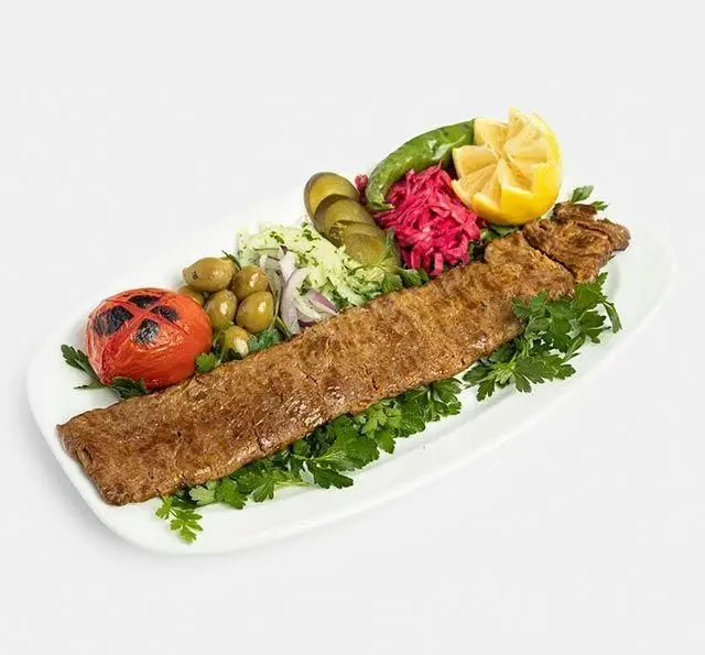 پرس کباب کوبیده رستوران سنتی آفاق با مخلفات متنوع از جمله گوجه کبابی، زیتون، پیاز، ترشی و فلفل. غذای سنتی ایرانی.