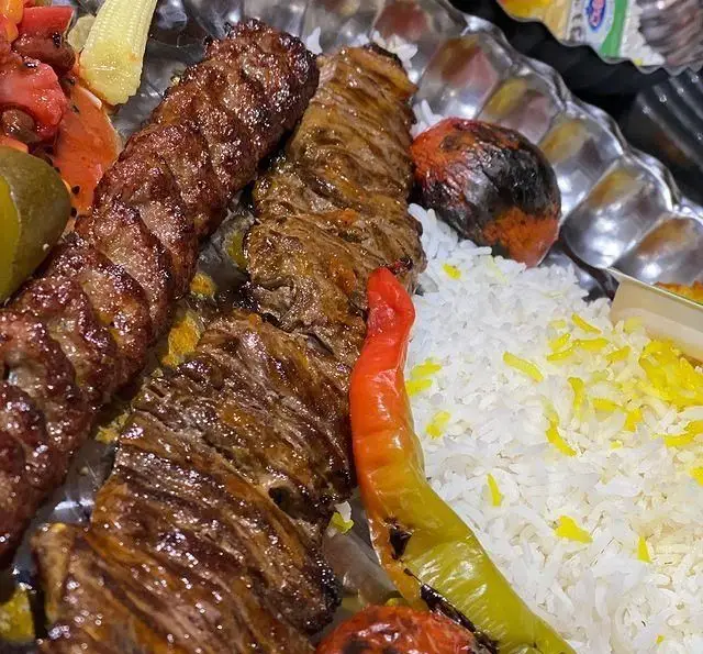 چلوکباب کوبیده و برگ لذیذ رستوران شب های تهران با برنج زعفرانی، گوجه و فلفل کبابی و ترشیجات خوشمزه.