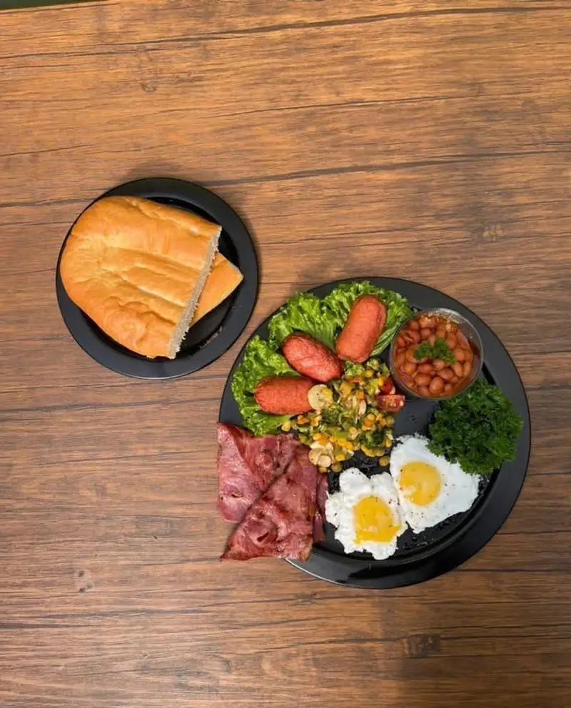 صبحانه کامل کافه رستوران حیات نو: شامل تخم مرغ، بیکن، سوسیس، سبزیجات، لوبیا و نان بربری تازه. ایده‌آل برای شروع روزی پرانرژی.