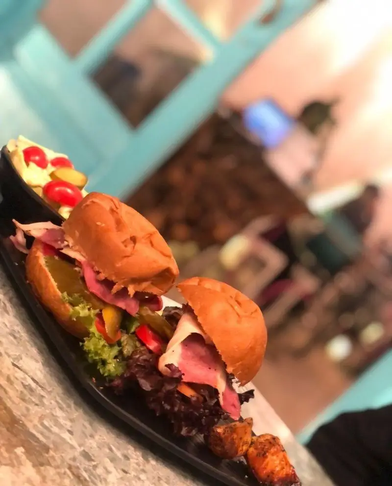 تصویری جذاب از دو برگر خوشمزه و اشتهاآور با گوشت لذیذ و سبزیجات تازه در کافه رستوران حیات نو، انتخابی عالی برای وعده غذایی شما.