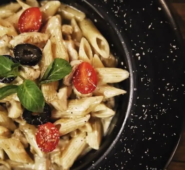 پاستا پنه خامه ای با گوجه گیلاسی، زیتون و سبزیجات تازه در کافه رستوران حیات نو. غذای ایتالیایی خوشمزه و خاص.