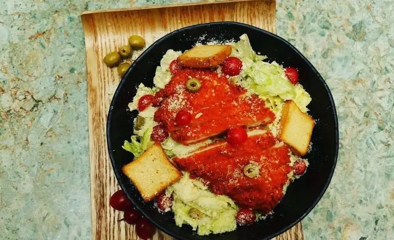 تصویری از سالاد مرغ سوخاری خاص کافه رستوران حیات نو، با کاهو، زیتون، گوجه گیلاسی و پنیر پارمزان. طعمی دلنشین.