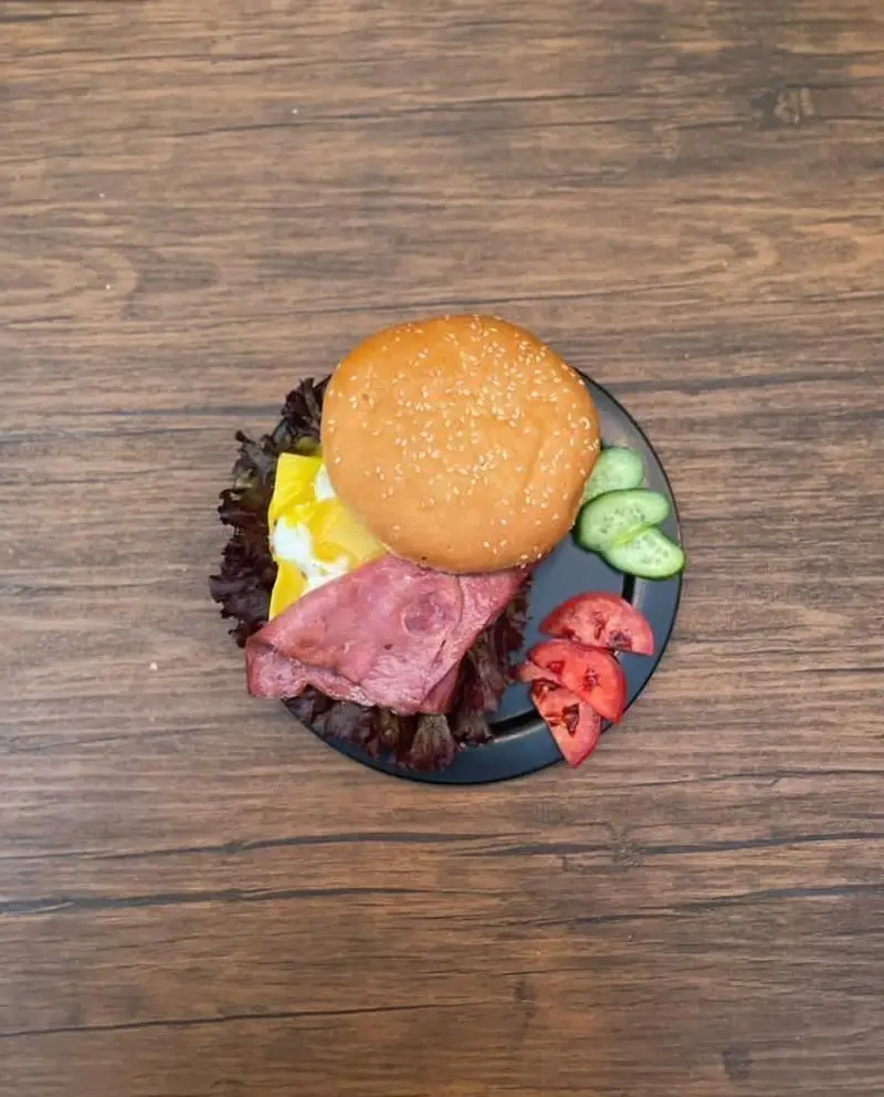 برگر ویژه کافه رستوران حیات نو با نان کنجدی، تخم مرغ، گوشت دودی و سبزیجات تازه، مناسب صبحانه و ناهار.