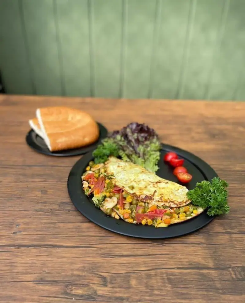 املت رنگارنگ سبزیجات (ذرت، نخود) با تزئین کاهو و گوجه در کافه رستوران حیات نو؛ یک انتخاب سالم برای صبحانه.