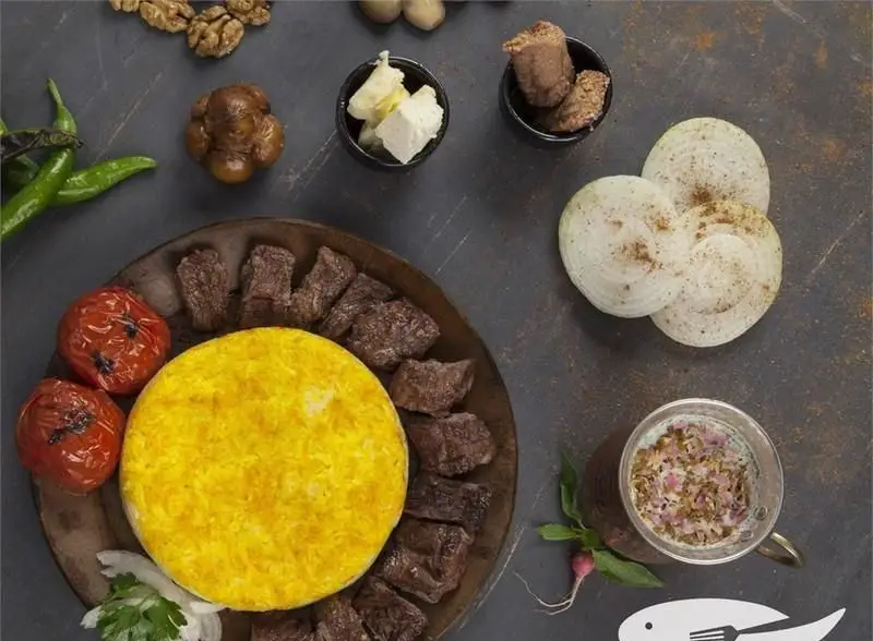 پلاتر چلوکباب لذیذ با برنج زعفرانی و گوشت کبابی، گوجه، پیاز، پنیر، دوغ و مخلفات. غذای سنتی ایرانی رستوران ماهی سفید.