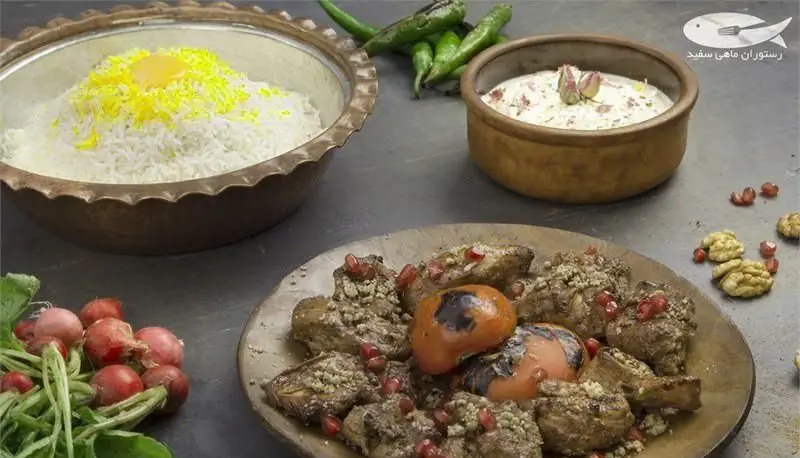 مجموعه‌ای لذیذ از غذاهای ایرانی در رستوران ماهی سفید: پلو زعفرانی، خورش انار و گردو، ماست، فلفل سبز، تربچه و گردو.