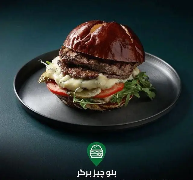 برگر دوبل بلو چیز آبدار با پنیر ذوب شده و سبزیجات تازه در کافه رستوران لوکال ولنجک، یک انتخاب خوشمزه و خاص برای مشتریان.