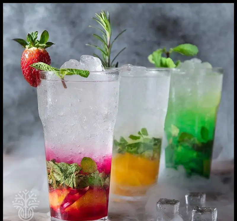 نوشیدنی‌های میوه‌ای خنک و رنگارنگ در کافه رستوران لوکال ولنجک شامل موهیتو توت‌فرنگی، پرتقالی و نعنایی با یخ فراوان و تزئینات زیبا.