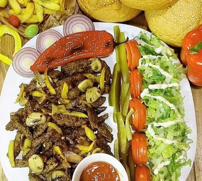 غذای ترکی دونر گوشت افندی شامل تکه های گوشت با قارچ و فلفل، نان، سیب زمینی، سالاد، خیارشور و سس. دونر افندی.