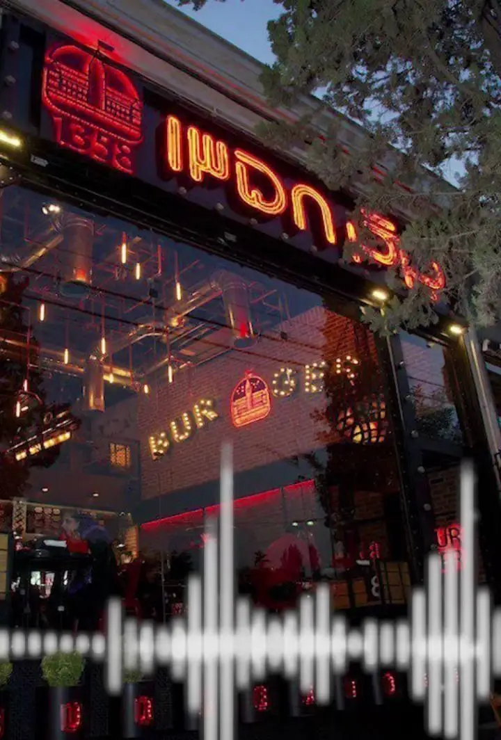 ورودی جذاب فست فود برگر 1358 بلوار اباذر در شب با نورپردازی نئون قرمز و لوگوی تاج، بازتاب دکوراسیون داخلی