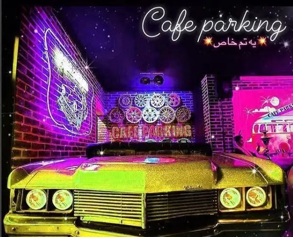 فضای داخلی کافه پارکینگ با طراحی خلاقانه تم خودرو، نورپردازی نئون بنفش و صورتی، دکوراسیون چرخ و رینگ، ارائه تجربه ای نو