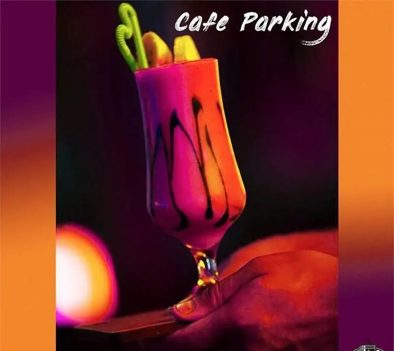 نوشیدنی صورتی جذاب کافه پارکینگ با تزیین میوه و شکلات، مناسب برای شب‌نشینی‌های دلنشین و تجربه‌ای خاص در کافی شاپ.