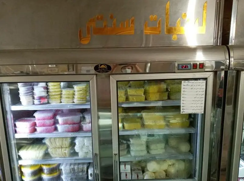 نمایی از فروشگاه لبنیات سنتی دهکده، با یخچال‌هایی پر از انواع محصولات لبنی تازه و با کیفیت شامل ماست، پنیر و دسرهای محلی.