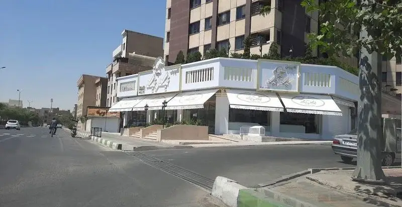 نمای بیرونی قنادی تیک و تیک، شیرینی‌فروشی لوکس با دکوراسیون سفید و تصاویر برجسته روی دیوار در کنار خیابان، تهران.