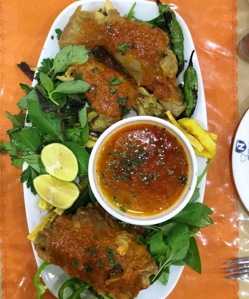 یک بشقاب غذای لذیذ ایرانی: مرغ مجلسی با سس مخصوص، سبزیجات تازه، لیمو و خورش در رستوران نمونه تهران.